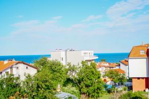 a city with houses and the ocean in the background at Chrystal Guest House in Obzor