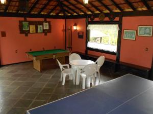 um quarto com uma mesa de pingue-pongue e cadeiras em Country Ville Hotel em Teresópolis