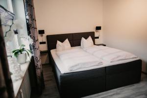 Ferienwohnung Maticevic في اوبرستدورف: سرير بشرشف ووسائد بيضاء في الغرفة
