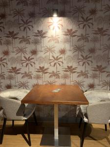 a table with two chairs and a wallpaper with palm trees at Hostel The Globe in Amsterdam