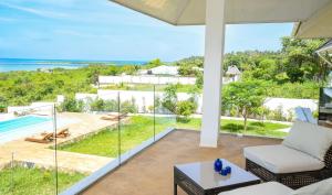 una sala de estar al aire libre con vistas al océano en The Palm Residence by Amazing Zanzibar en Chanjani