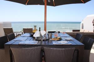 uma mesa com copos de vinho e um guarda-sol na praia em 15 Tontiki em Ballito