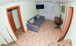 ein Wohnzimmer mit einem Sofa und einem Stuhl in der Unterkunft 2х комн. центр. на Соборной in Krementschuk