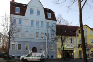 a white car parked in front of a large building at Ferienwohnung - Apartment mit Balkon in Halle-Saale, Trotha in Halle an der Saale