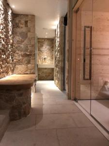 a hallway with a stone wall and a bench in a room at Villa San Liberale - Suites & Wellness in Feltre