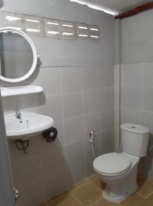 een badkamer met een toilet, een wastafel en een spiegel bij Blue Sky Bungalow in Ko Jum
