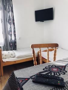 a room with a bed with a keyboard and a television at Pensjonat Makuch in Korbielów