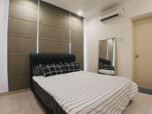 a bedroom with a bed with a black headboard and a mirror at Central Residence Homestay2 @ Sungai Besi, Kuala Lumpur in Kuala Lumpur