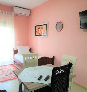 a room with a table and chairs and a bed at Comfort Apartments in Fier