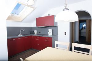 a kitchen with red cabinets and a dining table at Fideliushaus in Oberstdorf