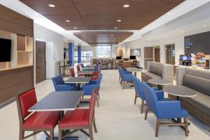 una sala da pranzo con tavoli e sedie blu di Holiday Inn Express & Suites - Hudson I-94, an IHG Hotel a Hudson