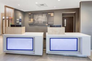 a reception desk with two blue screens in a lobby at Holiday Inn Express & Suites - Hudson I-94, an IHG Hotel in Hudson