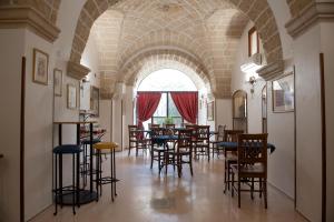 a dining room with chairs and tables in a building at Corte Baldi in Galatina