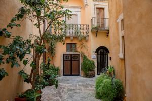 un callejón con una puerta en un edificio con plantas en Corte Baldi, en Galatina