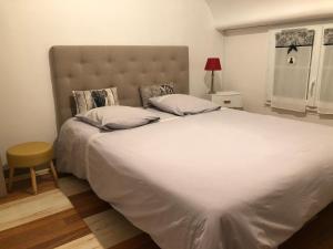 Schlafzimmer mit einem großen weißen Bett mit Kopfteil in der Unterkunft Le charme d'othe in Bellechaume