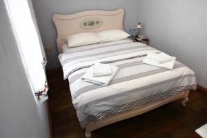 a bed with two white towels on top of it at Kidalyo Hotel - Special Category in Ayvalık