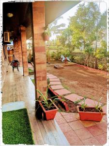 a porch with two potted plants on a house at Ivy Orchids Villa - Lonavala in Lonavala