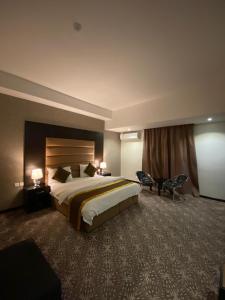a large hotel room with a bed and two chairs at Desert Rose in Hail +56 photos