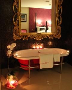 a bath room with a tub and a mirror at The Talbot Hotel in Belmullet