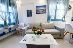 salon z kanapą i stołem z kwiatami w obiekcie Located by the sea one beachfront Private Captain Lazaros Pool Villa with loft in 750sqm spacious private plot-Jacuzzi-sunrelax-furnished terace-gazebo-private parking,sleep 3 adults and 2 children, just steps from the Black Beach-Seaview w mieście Perissa