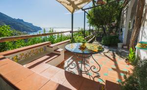 a patio with a table and bench and the ocean at B&B Orto Paradiso in Minori
