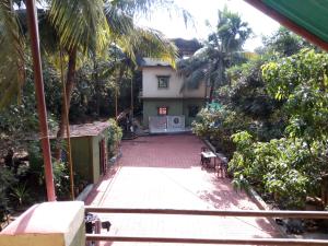 una vista esterna di una casa con palme di Sachin homestay a Mandrem