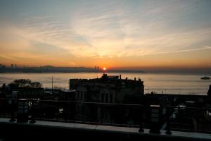 zachód słońca nad wodą z budynkiem na pierwszym planie w obiekcie Ligos w Stambule