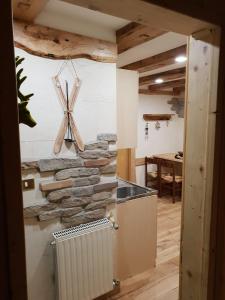 a kitchen with a stone wall with a radiator at Cervus in Passo del Tonale