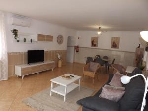 a living room with a couch and a tv and a table at Apartamento Mariamar in Olhos de Água