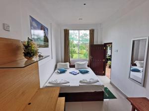 una camera da letto con un letto in una stanza con una finestra di Sigiriya Water Guest & View Point Restaurant a Sigiriya