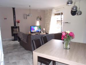 a living room with a couch and a table with flowers at petit coin au calme in Baulon