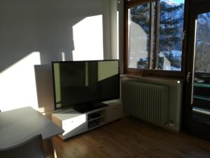 a living room with a flat screen tv and a window at Apartment Alpenpanorama in Goldegg