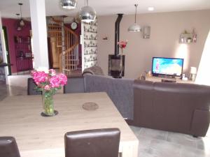 a living room with a couch and a table with flowers at petit coin au calme in Baulon