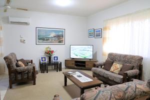 a living room with a couch and a tv at Capon Cottage in Broken Hill