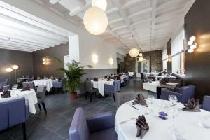 une salle à manger avec des tables blanches et des chaises bleues dans l'établissement Hotel Restaurant Perle Des Vosges, à Muhlbach-sur-Munster