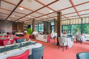 a restaurant with white tables and chairs and windows at Hotel Ker Juliette in Pornichet