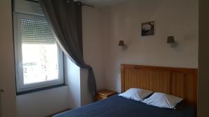 a bedroom with a bed and a window at HOTEL DE FRANCE in Maubourguet