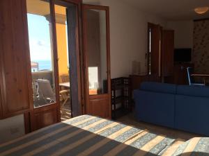 a bedroom with a bed and a blue couch at Appartamenti fronte mare in Castiglioncello