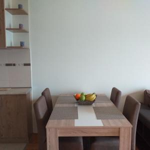 a wooden table with a bowl of fruit on it at Aphrodite Apartment in Podgorica