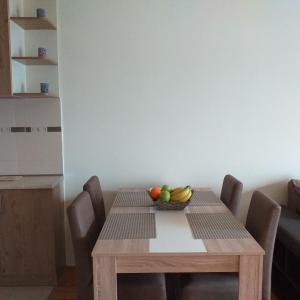 een houten tafel met een fruitschaal erop bij Aphrodite Apartment in Podgorica