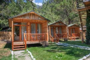 a couple of wooden cabins in a yard at Sea Valley Lodge in Faralya