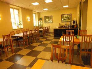 a restaurant with tables and chairs and a checkered floor at Hotel Eco in Łowicz