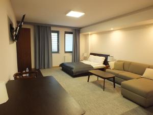 - un salon avec un canapé et un lit dans une chambre dans l'établissement Hotel Eco, à Łowicz
