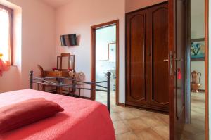 a bedroom with a bed with a red blanket and a mirror at La casa di Nunzi in Cortona