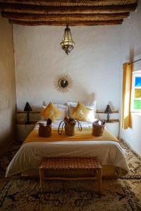 a bedroom with a large bed and a window at Riad Kasbah Aiour in Merzouga