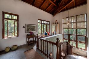 阿利巴格的住宿－SaffronStays Thalassea, Alibaug - picturesque sea-facing villa with colonial decor，客厅设有楼梯和窗户。