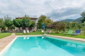 a swimming pool in a yard with chairs and a house at La casa di Nunzi in Cortona