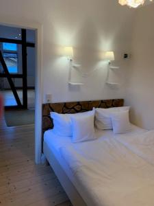 ein Schlafzimmer mit einem weißen Bett mit weißen Kissen in der Unterkunft Appartment 5 in Braunlage