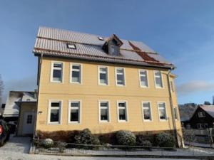 ein großes gelbes Haus mit rotem Dach in der Unterkunft Appartment 5 in Braunlage