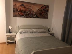 1 dormitorio con 1 cama y una pintura en la pared en A casa di Titty, en Somma Lombardo